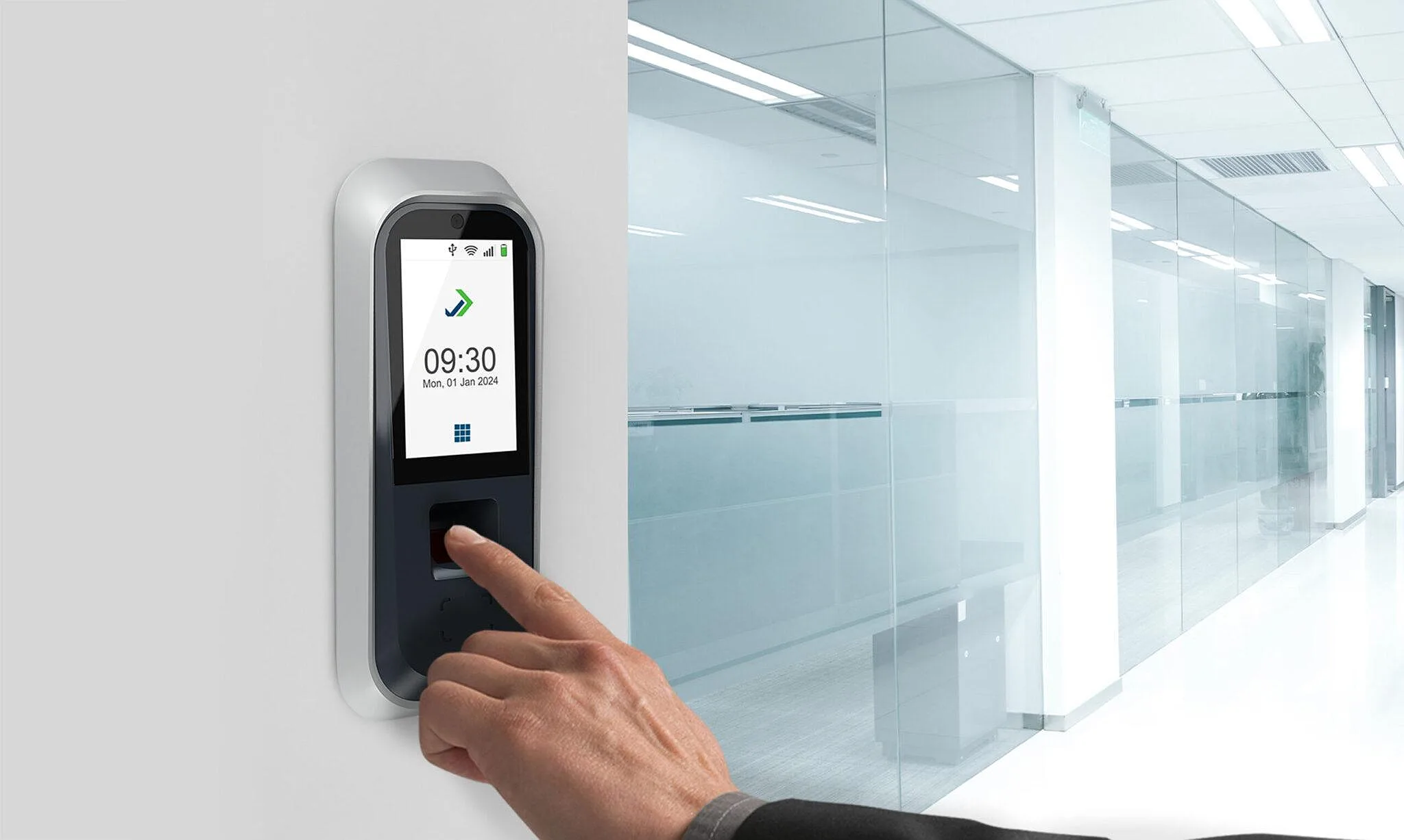 Employee checking in at a wall-mounted terminal in an office corridor