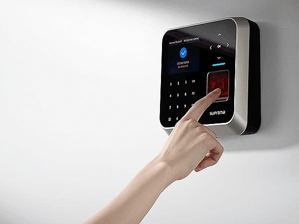 Employee checking in on a wall-mounted fingerprint terminal